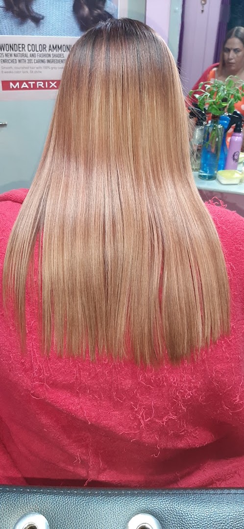 Straight blonde-brown hair over a red cardigan