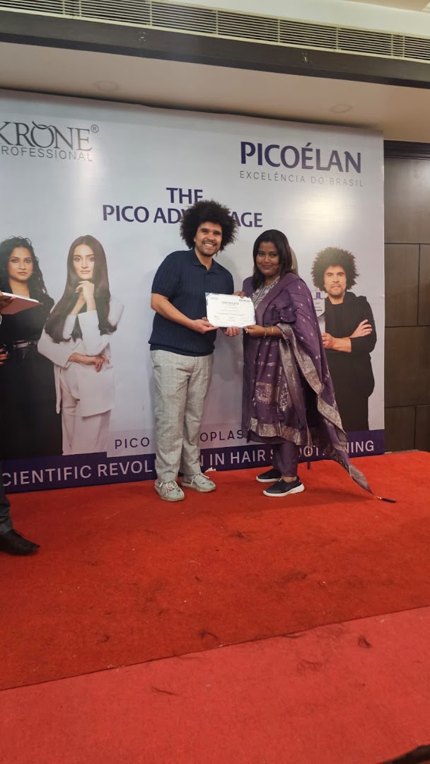 Sumona holding a certificate beside the trainer at a Krone Picoélan hair event